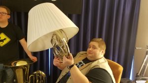 John Robert holding up a horn in a lampshade at MAGfest 2018